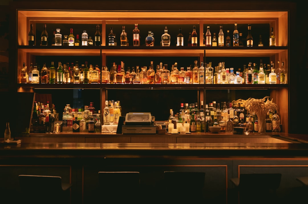 Warmly lit back bar stocked with spirits at a neighborhood pub